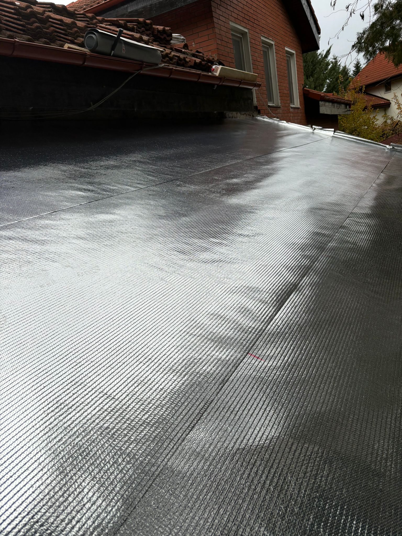 Folie anticondens Isoflect Roof Eco montată pe acoperiș — detaliu al suprafeței reflective aluminizate, cu suprapunerile membranelor sigilate